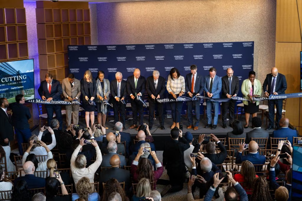 University leaders on stage at 111 Mass Ave, cutting the ceremonial ribbon.